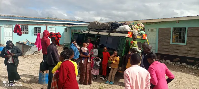 The mission team arriving with a loaded vehicle, greeted by families